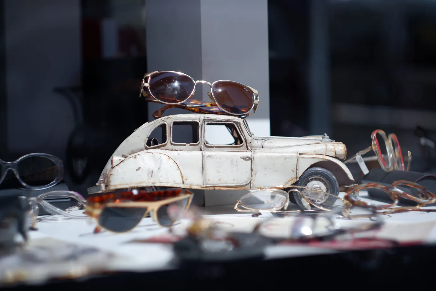 Çarşı Optik window display: leopard-print sunglasses and a classic toy car, Antalya